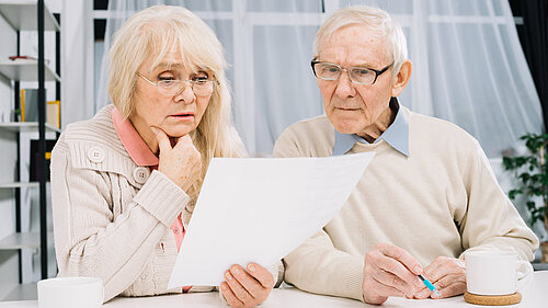 Couple look with concern at a bill they have received